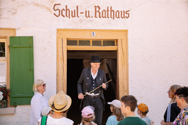 Bild vergr&ouml;&szlig;ern: Dorschulmeister vor dem Schul- und Rathaus